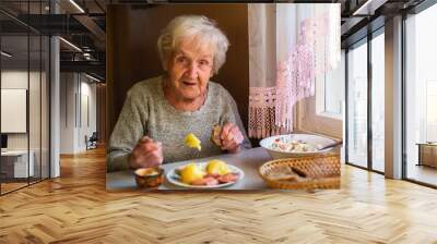 An elderly woman portrait dines in his home. Wall mural