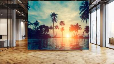 Beautiful tropical beach with palm trees silhouettes at dusk. Wall mural