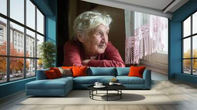 Close-up portrait of an elderly woman near the window.. Wall mural