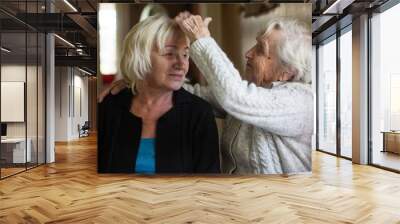 Elderly woman is having fun with her adult daughter. Wall mural