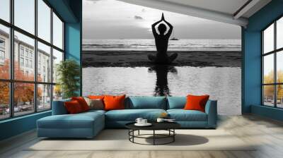 silhouette young woman practicing yoga on the beach. black-and-white contrast photo. Wall mural