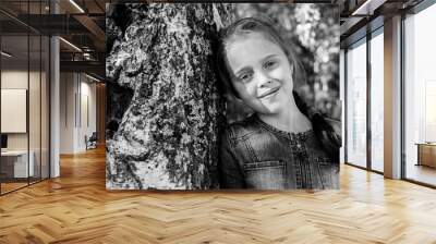 Ten-years-old girl in the woods near birch. Black and white photo. Wall mural