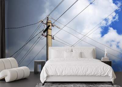 Electric pole and intersecting wires on a background of blue sky and clouds. Illustration on the theme of electricity transportation, electrification of the countryside, rising energy prices Wall mural