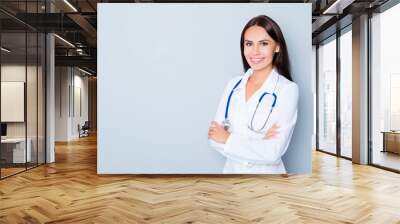 Cheerful happy doctor  with crossed hands on blue background Wall mural