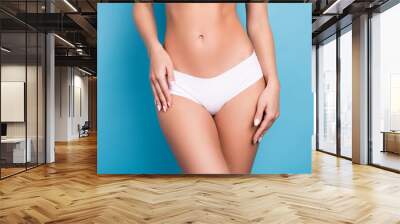 Close up cropped portrait of sportive nice girl skinny abdominal isolated on blue color background Wall mural