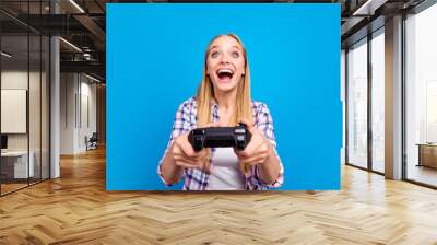 Close up of happy young blond girl holding joystick in hands and Wall mural