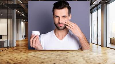 Close up photo amazing he him his macho perfect ideal appearance neat stubble advising recommending buy buyer hold hand arm novelty facial cream wear casual white t-shirt isolated grey background Wall mural