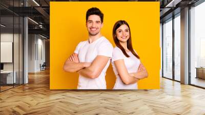 Close up photo beautiful she her he him his pair stand back side close teamwork self-confident professionals specialists work job reliable workers wear casual white t-shirts isolated yellow background Wall mural