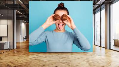 Close up photo beautiful she her lady hide eyes advising buy buyer try new yummy just baked tasty cacao color muffins tongue out mouth wear casual sweater pullover isolated blue bright background Wall mural