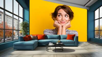 Close up photo of adorable lovely girl two arms touch face look empty space offer banner isolated on yellow color background Wall mural