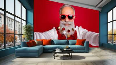 Close up photo of cheerful hipster in eyeglasses eyewear make photo have collection of decorative balls wear white jumper isolated over red background Wall mural