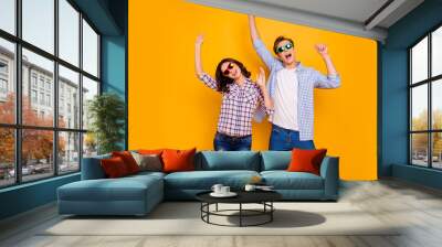 Close up photo of pair in summer specs he him his she her lady boy hands up dancing yelling cheer great bit luck wearing casual plaid shirts outfit isolated on yellow background Wall mural