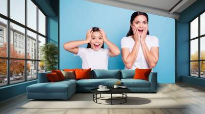 Close up photo pretty two people brown haired mum little daughter eyes mouth opened unbelievable arms on face head yelling sale discount wearing white t-shirts isolated bright blue background Wall mural