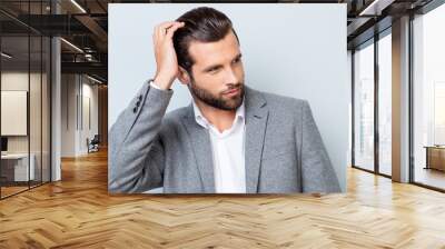 Close up portrait of handsome confident masculine man in jacket touching his hair Wall mural