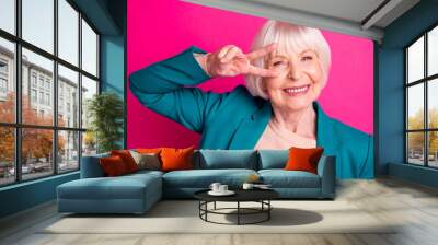 Close-up portrait of her she nice attractive cheerful cheery funky gray-haired lady wearing blue jacket showing v-sign near eye isolated on bright vivid shine vibrant pink fuchsia color background Wall mural