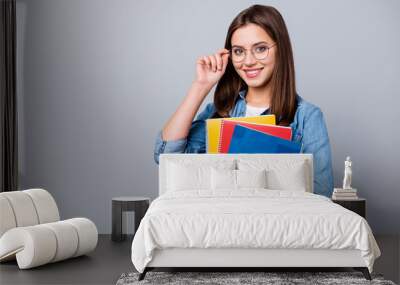 Close-up portrait of her she nice attractive lovely charming intelligent cheerful cheery girl holding in hands lesson exam test book materials isolated over grey pastel color background Wall mural