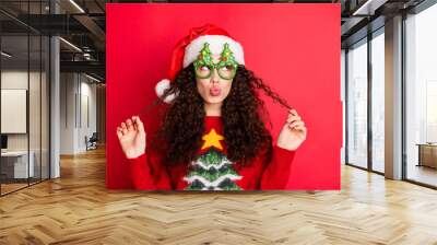 Close-up portrait of her she nice-looking attractive lovely pretty cheerful flirty wavy-haired Santa girl pouted lips playing with curls isolated over bright vivid shine vibrant red color background Wall mural