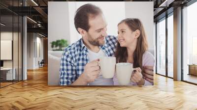 Close-up portrait of his he her she nice cute lovely attractive cheerful peaceful pre-teen girl handsome bearded dad daddy sitting on divan drinking cacao in modern light white interior room indoors Wall mural