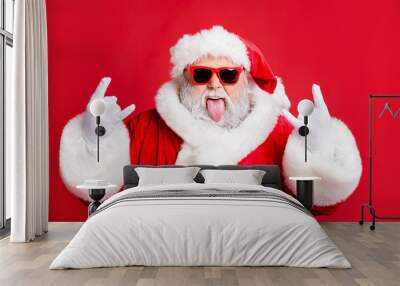 Close-up portrait of his he nice attractive positive playful bearded Santa having fun leisure showing horns symbol sign heavy metal fest isolated over bright vivid shine red background Wall mural