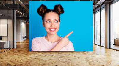 Closeup photo of attractive pretty lady two funny buns direct finger side empty space showing novelty sale product wear casual white pink t-shirt isolated blue color background Wall mural