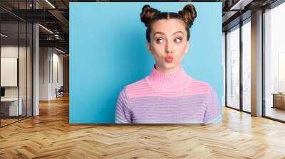 Closeup photo of attractive teen lady two funny buns good mood charming cute nice youngster look side empty space sending air kisses wear casual warm sweater isolated blue color background Wall mural