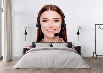 Closeup portrait of successful young brunette girl, who is wearing headset on a pure white background. She is in a casual checkered shirt, smiling Wall mural