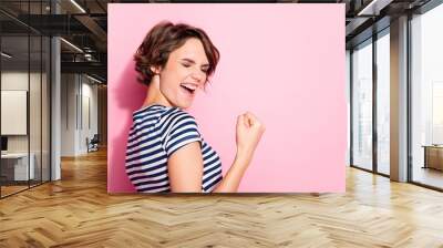 Closeup profile photo of pretty lady good mood raise fist celebrating successful sports game match ending wear casual white blue striped t-shirt isolated pastel pink color background Wall mural