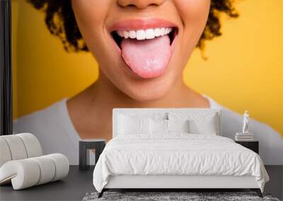 Cropped close up photo beautiful amazing she her dark skin lady beaming whitening toothy smile tongue out perfect mouth wear casual white t-shirt isolated yellow bright vibrant background Wall mural