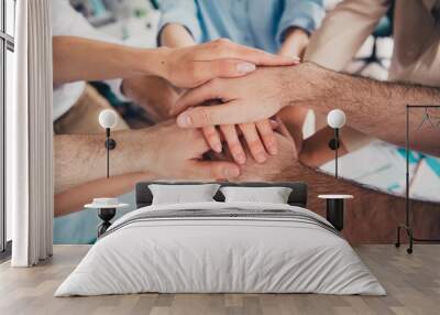 Cropped portrait of group professional corporate workers pile stack handshake loft interior business center indoors Wall mural