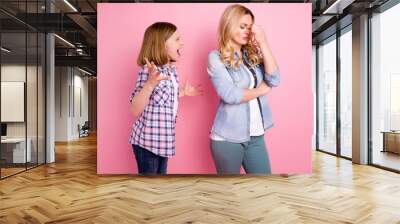 Frustrated two people aggressive kid girl yell scream mother touch nose suffer headache hate family misunderstanding wear denim jeans checkered plaid shirt isolated pastel color background Wall mural