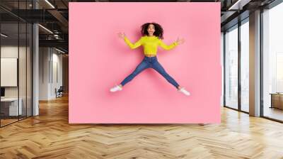 Full body length photo of sporty youth funny girl wearing green sweater and jeans jumping showing star figure isolated on pink color background Wall mural