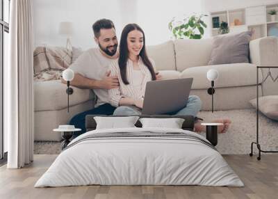 Full body photo of cheerful young couple enjoy weekend couple wife husband sit floor netbook buy new apartment indoors inside house home Wall mural