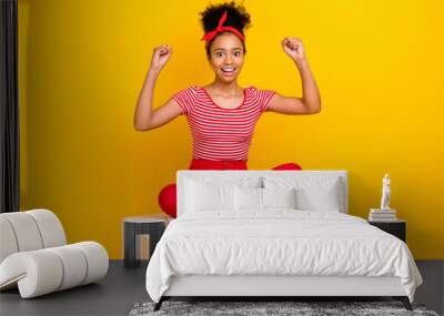 Full body photo of pretty young girl raise fists sit white podium wear trendy red striped outfit isolated on yellow color background Wall mural