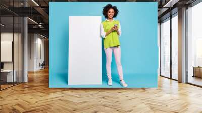 Full body photo of sweet young brunette lady with telephone wear spectacles vest pants shoes isolated on blue background Wall mural