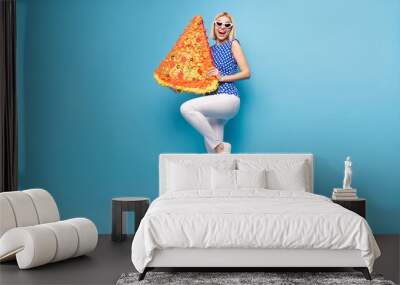 Full body photo of young cheerful girl happy positive smile hold paper pinata italian pizza yummy isolated over blue color background Wall mural