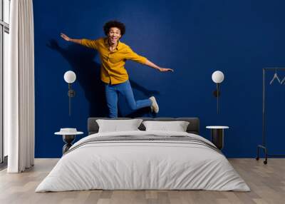 Full body portrait of nice young man dancing empty space wear yellow shirt isolated on dark blue color background Wall mural