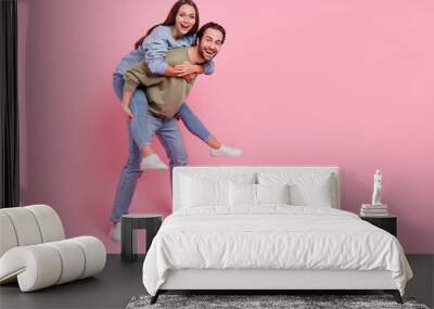 Full body profile portrait of two carefree people carry piggyback enjoy free time isolated on pink color background Wall mural