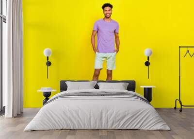 Full body size cadre of young smiling happy man student summer outfit model blue shorts violet t-shirt isolated on yellow color background Wall mural