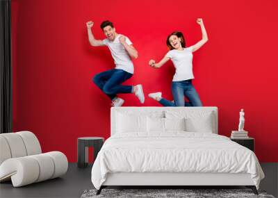 Full length body size photo of cheerful positive crazy excited overjoyed ecstatic couple boyfriend girlfriend screaming wearing jeans denim jumping white t-shirt isolated vivid color background Wall mural