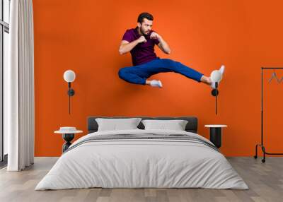 Full length body size profile side photo of serious confident man in blue trousers white sneakers kicking his leg forward to protect himself isolated vivid color background Wall mural