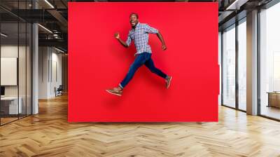 Full length body size profile side view of nice funny handsome cheerful positive sportive guy wearing checkered shirt running in air isolated on bright vivid shine red background Wall mural