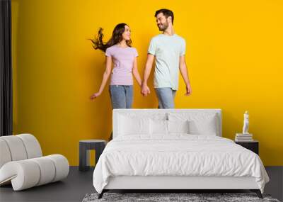 Full length body size view of attractive affectionate dreamy cheerful couple going holding hands isolated over bright yellow color background Wall mural