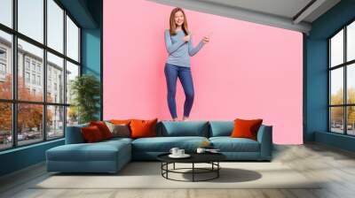 Full length body size view of attractive cheerful girl demonstrating copy space ad isolated over pink pastel color background Wall mural