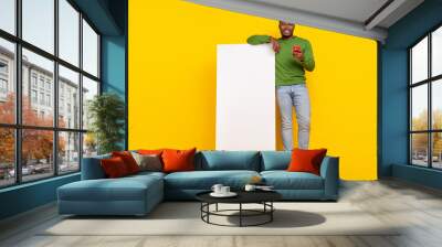 Full length body size view of attractive cheerful guy using device 5g post smm ad isolated on bright yellow color background Wall mural