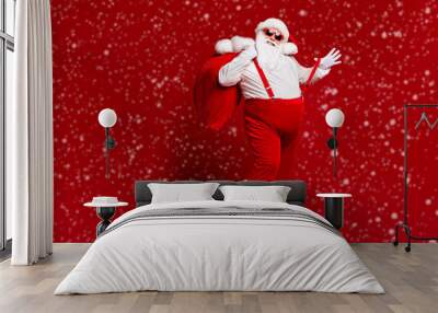 Full length body size view of his he attractive playful cheerful funny fat Santa carrying big large sack having fun fooling enjoying isolated bright vivid shine vibrant red color background Wall mural