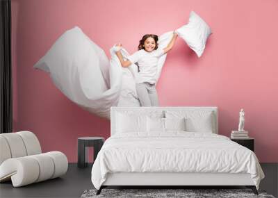 Full length body size view of nice attractive cute playful cheerful cheery wavy-haired pre-teen girl jumping flying with soft cotton pillow blanket isolated over pink pastel color background Wall mural