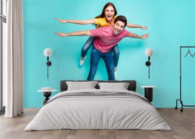 Full length body size view of nice attractive playful funny cheerful cheery couple guy carrying girl having fun like flying isolated over bright vivid shine vibrant green turquoise background Wall mural