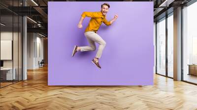 Full length body size view portrait of nice funky glad cheerful guy jumping running isolated over violet purple color background Wall mural