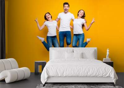 Full length body size view portrait of three nice attractive slim fit cheerful cheery person buddy fellow having fun showing v-sign isolated over bright vivid shine yellow background Wall mural