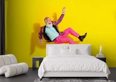 Full length photo of attractive retired man falling down dressed stylish colorful pink fancy clothes isolated on yellow color background Wall mural